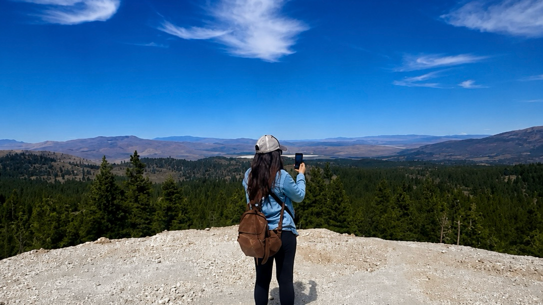 Eagle Creek Studio- taking a photo of a scenic landscape with mountains and blue sky.