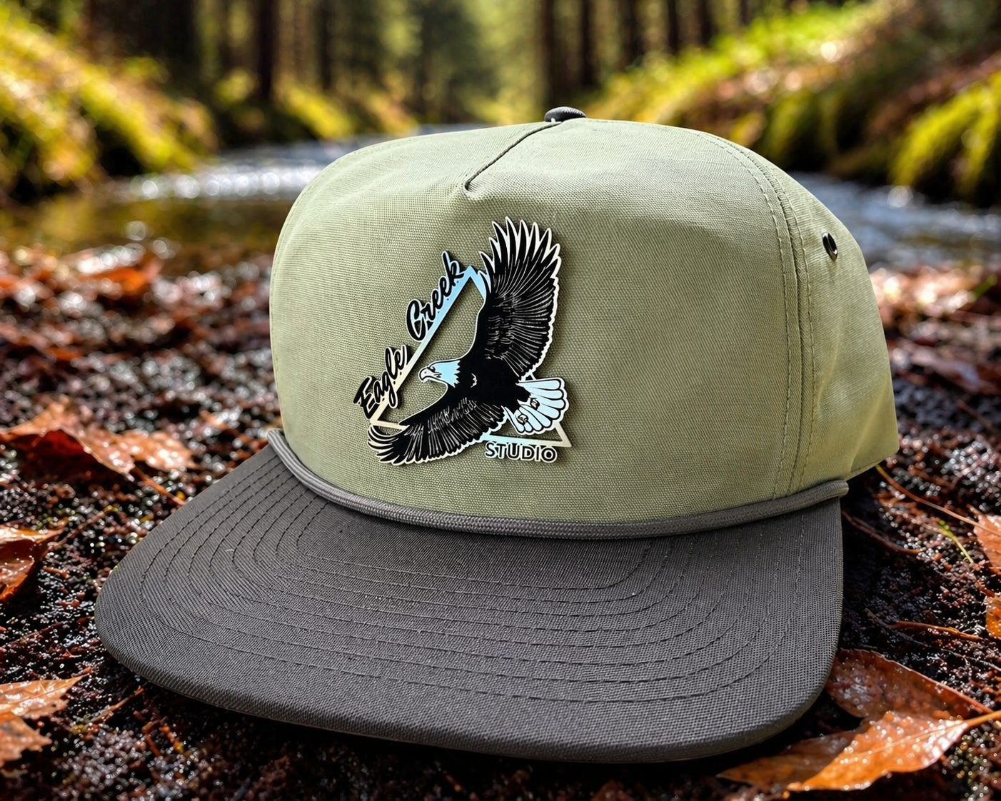 Eagle Creek Elevation Hat with leather patch on forest creek background